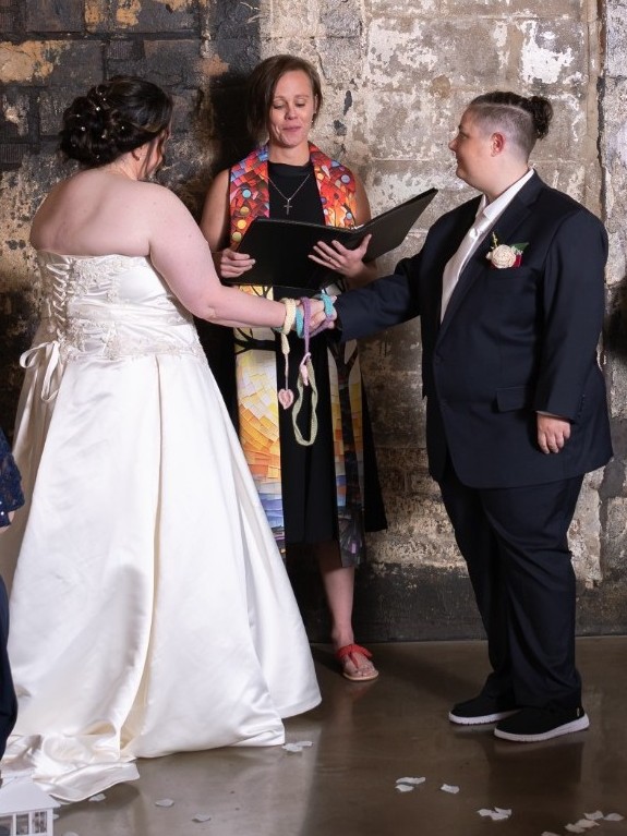Jessica officiating a handfasting ceremony for two brides